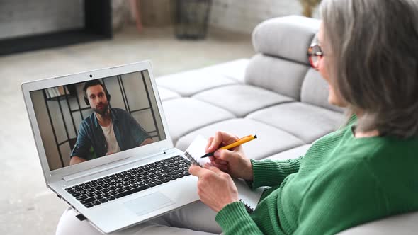 Mature Senior Woman is Using a Laptop for Video Call at Home alt