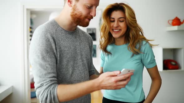 Funny Couple or Marriage Sharing a Smart Phone to Watch Media