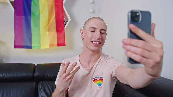 Proud Bald Gay Influencer Takes a Video of Himself with Smartphone Rainbow Pride Flag in the alt