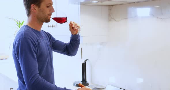 Man cooking food while having glass of red wine 4k alt