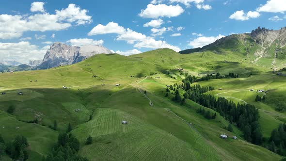 Dolomites Mountains with hiking paths and wooden cottages alt
