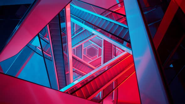 Puzzling labyrinth of escalators made of glass and steel. Blue and red light. alt