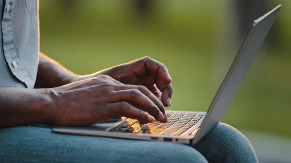 African Man Professional Busy Worker Freelancer Blogger User Typing on Laptop Sit Outdoor Close Up alt