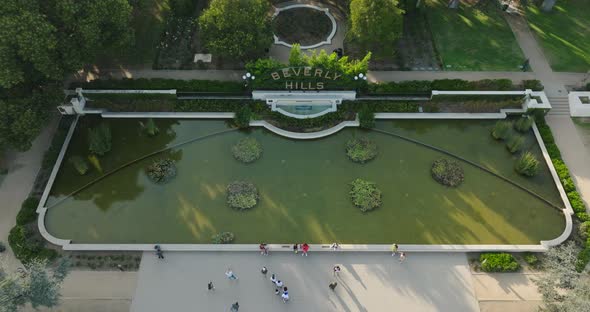 Drone Flying Above Famous Beverly Hills Sign by Fountain on Green Lawn, Garden Landmark in Los Angel alt