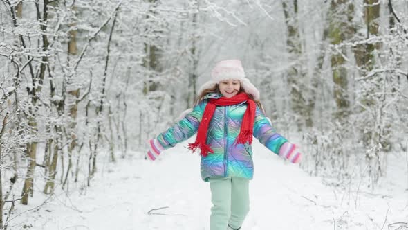 Happy Child Girl Plays With a Snow is Having Fun Running in Snowy in Winter Day