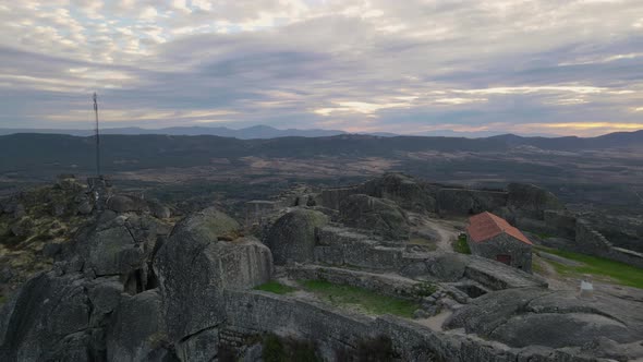 One person on walls of Monsanto castle at sunrise, Portugal. Aerial drone view alt