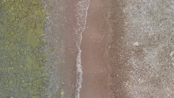 Aerial drone slow motion footage of waves hitting beach on the adriatic sea. alt