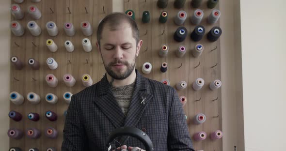 Man Putting on Headphones Holding Earcups and Nodding Head with Closed Eyes alt