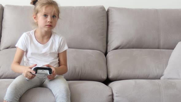 Competitive Girl Playing with Gamepad on Couch
