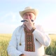 An Elderly Ukrainian in an Embroidered Jacket Playing the Harmonica in the Middle of a Wheat Field - VideoHive Item for Sale
