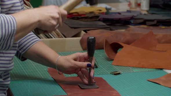 Female Worker Making Notches with Hummer and Metal Puncher Indoors alt