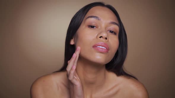 Africanamercian Woman Examining Face for Wrinkles After Cosmetology Procedure alt