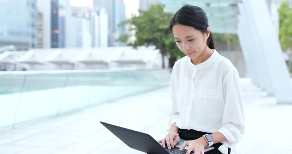 Business woman use of notebook computer in city alt