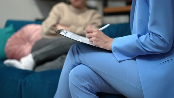 Side View Unrecognizable Expert Psychologist Writing with Pen As Blurred Teenage Girl Sitting on alt