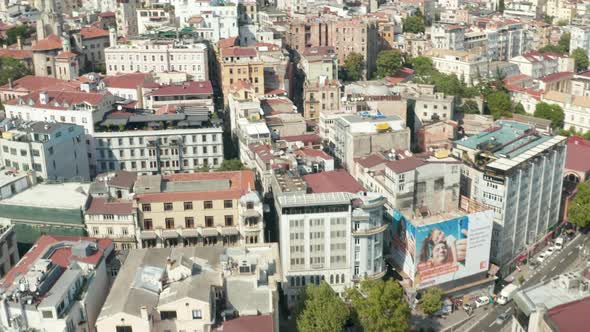 City Streets of Istanbul Tilt Up To Reveal Galata Tower in Taksim on Sunny Day, Aerial Wide alt
