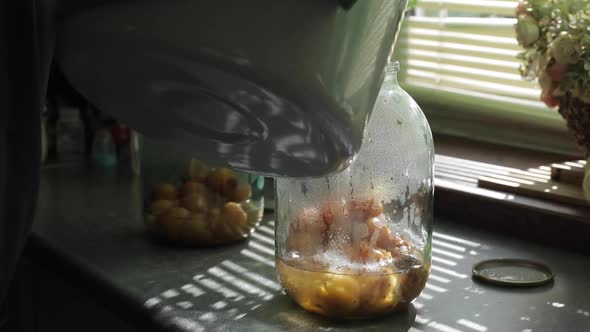 A Man Rolls Up a Jar of Fruit Preserves