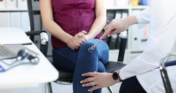 Neurologist Checks Nerve Reflexes with Hammer on Patient Knee Closeup alt