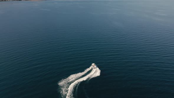 Drone View Of Speedboat Making Quick Turns On Vibrant Blue Water alt
