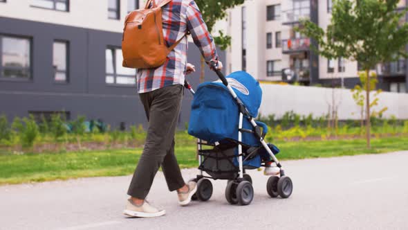 Father with Baby in Stroller Walking Along City alt