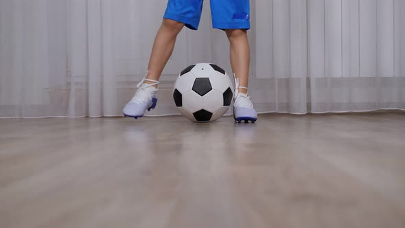 A Little Boy in a Cleats Trains at Home with a Ball During Quarantine alt
