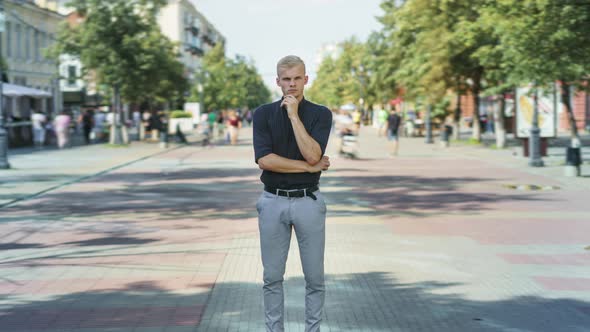 Zoomin Time Lapse of Pensive Guy in Elegant Clothing Standing Outside in Pedestrian Street alt