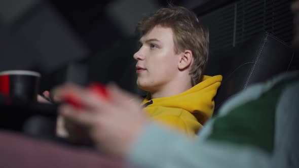 Young Gamers in a Movie Theater, Two Friends Playing Video Games on a Game Console, Playing Games on alt