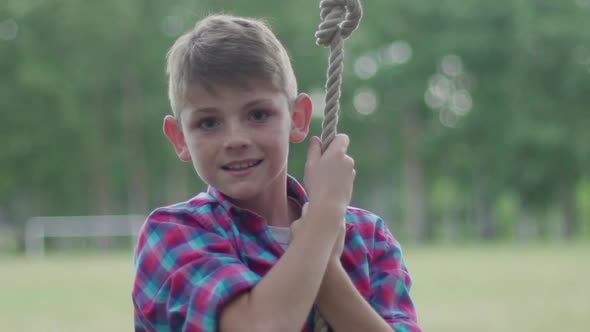 Boy swinging on rope outdoors