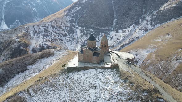 Gergeti Trinity Church Located on the Top of a Hill Greenery Valley Village on the Background