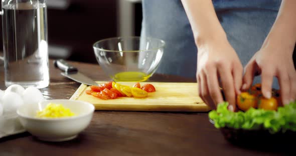Woman Prepares a Salad of Fresh Vegetables in a Modern Kitchen