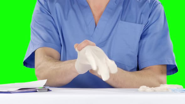 Medical Doctor Putting on Gloves, Green Screen alt