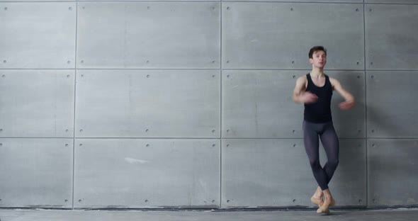 Male Ballet Dancer Performs Acrobatic Elements of a Ballet Dance on a Gray Background  Slow Motion alt