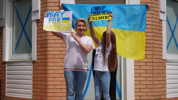 Ukrainian Mother and Daughters Posing with Help Ukraine Placards Standing on Summer Porch Outdoors alt