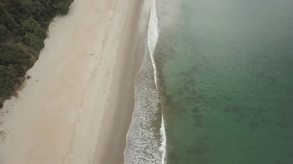 Calm waves on a beach in New Zealand in the Bay Of Islands. alt
