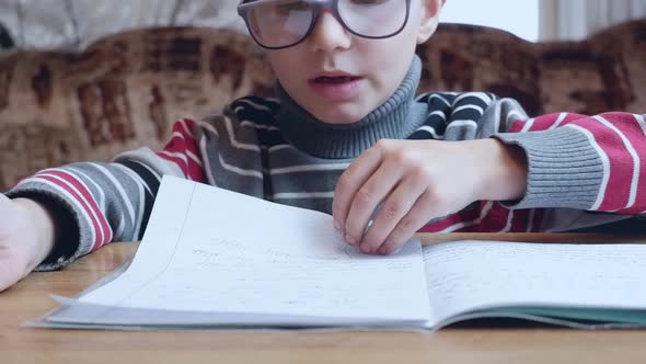 First Grader Boy Learns to Write and Does Homework alt