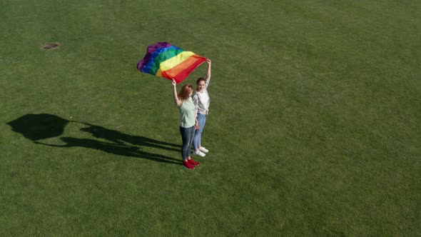 Aerial View of Lgbt Couple Holding Rainbow Flag alt