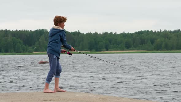 Boy With A Spinning Rod On A Lake Pier