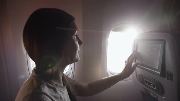 Woman Chooses Music Program in Liner Passenger Cabin Closeup alt