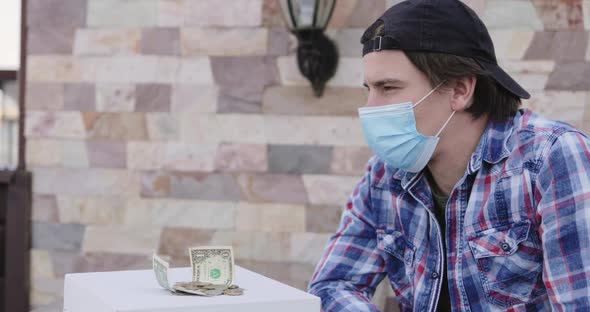 Thougtful Man Looks at Banknotes and is Sad From Saving Financial Income alt