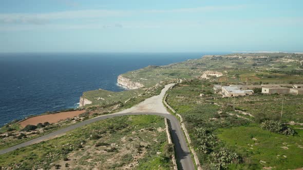 AERIAL: Flying Over Road On Dingli Cliffs with Mediterranean Sea in the Background on Sunny Day