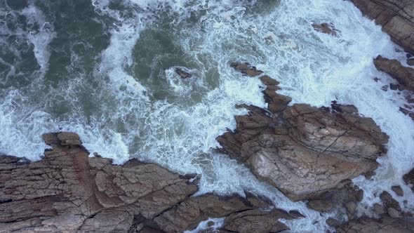 Aerial over a rocky coastline with waves breaking