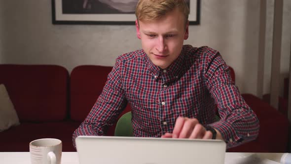 Smiling Caucasian Businessman Typing on Laptop Doing Research alt