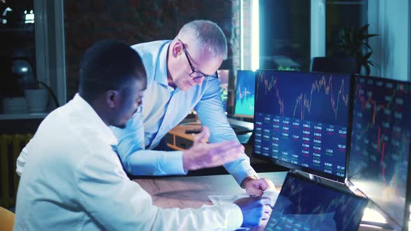 Male Stockbrokers are Analyzing Reports with Stock Information alt