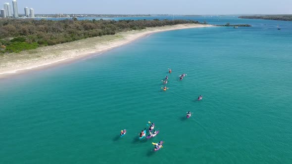 A large group of kayaks exploring the coastline alt