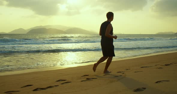 Jogging on the Sand on the Beach at Sunset Against the Backdrop of the Beautiful Sea Big Beautiful alt