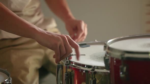 Drummer preparing snare drum, tuning it for the best sound possible before practice begins. alt