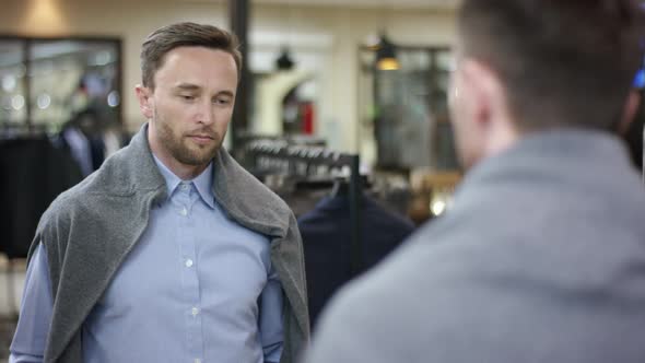 A Close Up Filming Over the Shoulder of a Businessman in a Blue Shirt Looking at His Reflection in