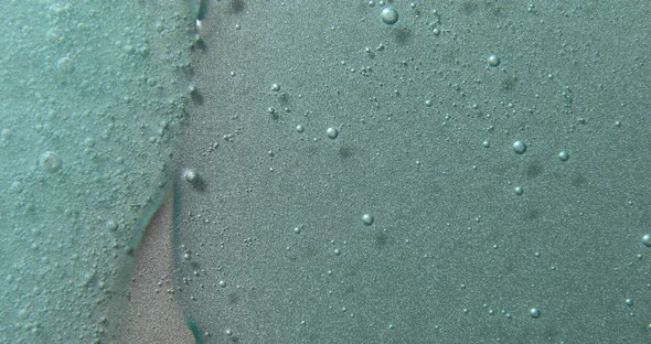 Blue cream liquid gel serum flowing down on silver texture