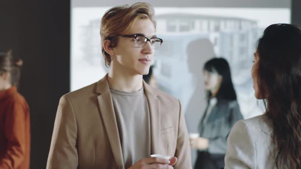 Young Man Talking with Female Colleague on Business Event alt