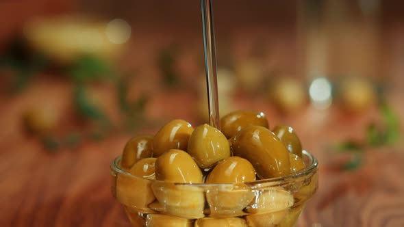 Olive Oil Green Oilves on Brown Background Closeup alt