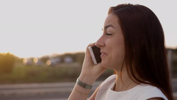 Smiling Lovely Young Girl Talking on Smartphone on Street alt